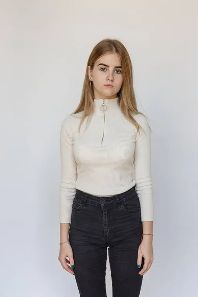 Portret młodej przemyślanej nastolatki modelki w białym swetrze i czarnych dżinsach — Zdjęcie stockowe
