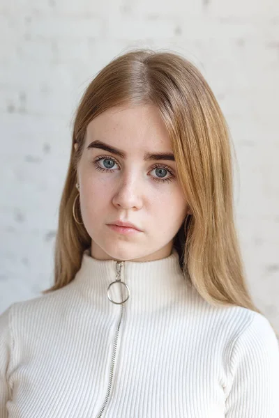 Close-up retrato de modelo adolescente pensativo com olhos azuis vestindo camisola branca — Fotografia de Stock