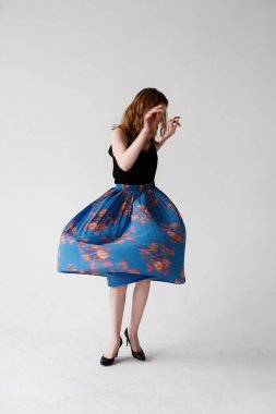 Beyaz tenli, mavi etekli, iç mekan portresi giymiş genç bir kadının bulanık hareketleri.