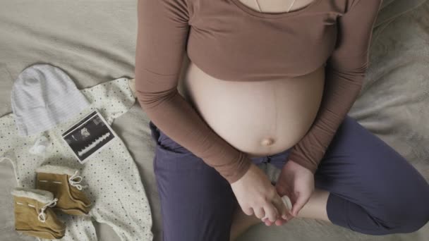 Expecting pregnant woman with big belly sitting on couch at home, taking pills — Stock Video