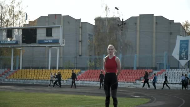 Kavkazská hezká žena stojící na stadionu před skupinou školáků — Stock video