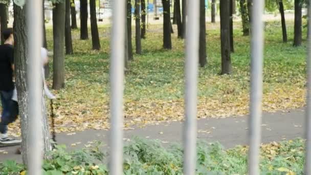 RUSSIA, VLADIMIR, 03 PAŹDZIERNIK 2020: dwóch młodych chłopców jeździ na skuterach w jesiennym parku — Wideo stockowe