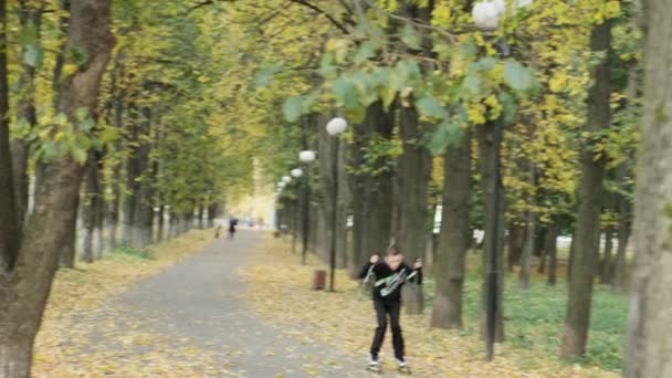 RUSIA, VLADIMIR, 03 OCT 2020: los niños pequeños montan en patines en el parque de otoño — Vídeo de stock