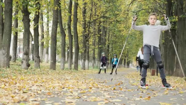 RUSIA, VLADIMIR, 03 OCT 2020: los niños pequeños montan en patines en el parque de otoño — Vídeo de stock