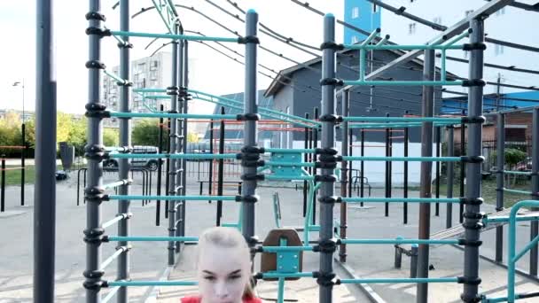 Młody pasuje blondynka busty kobieta z kucyk w czerwony top squatting na boisko sportowe — Wideo stockowe