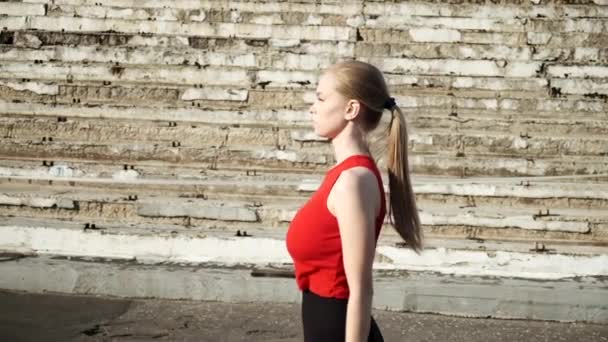 In forma caucasico procace bella donna cammina all'aperto lungo rovinato statium tribune — Video Stock