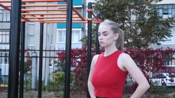 RUSSLAND, VLADIMIR, 06. OKT 2020: junge, fitte, vollbusige Frau steht am Sportplatz — Stockvideo