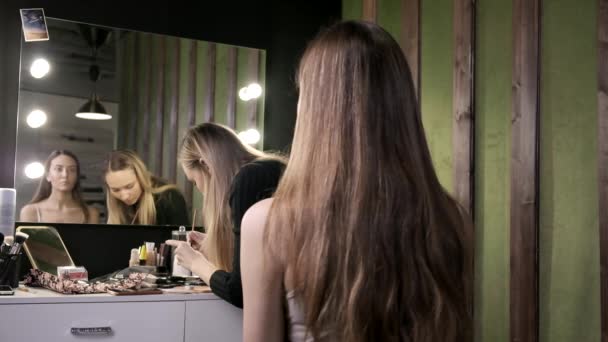 Attrayant maquilleur caucasien faire maquillage pour jeune femme dans le salon de beauté — Video