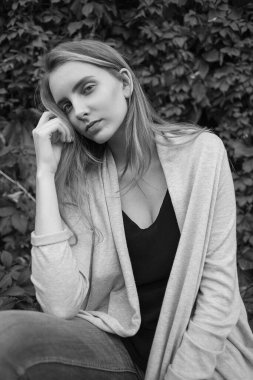 Çalı yaprağının önünde poz veren doğal beyaz kadın.