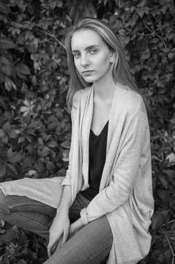 Çalı yaprağının önünde poz veren doğal beyaz kadın.