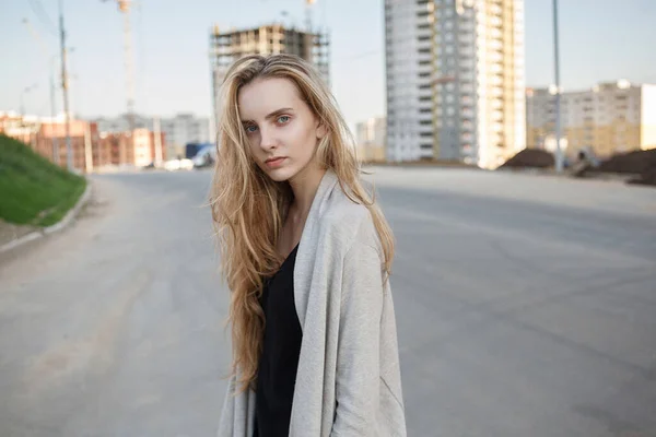 Femme maigre caucasienne avec les cheveux bruns à l'extérieur devant le chantier de construction — Photo