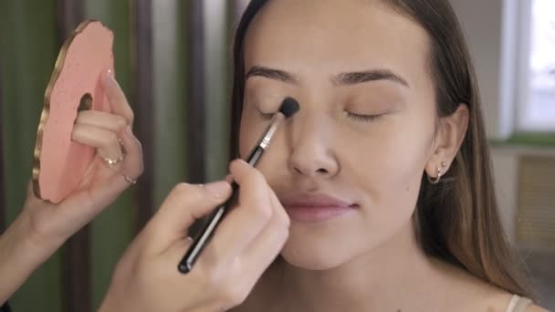 Make up művész csinál smink barna ázsiai nő ecset szépségszalonban — Stock videók