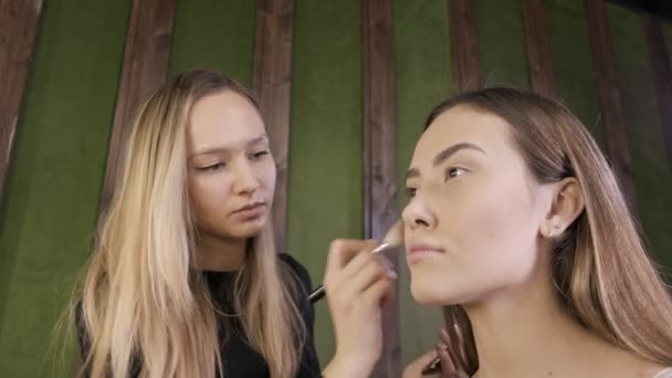 Attrayant caucasien maquilleur faire maquillage pour asiatique femelle dans salon de beauté — Video