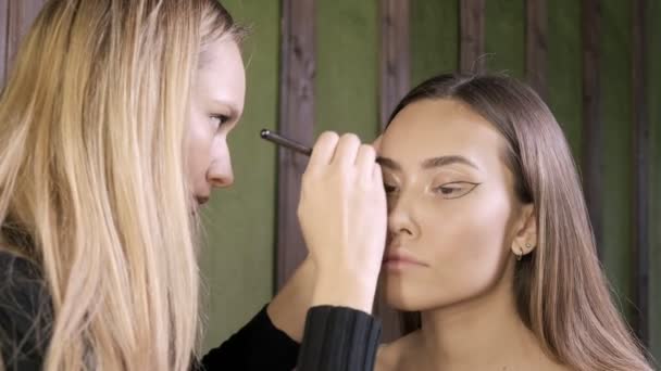 Atrakcyjny biały makijaż artysta robi makijaż dla Azji kobieta w salon piękności — Wideo stockowe