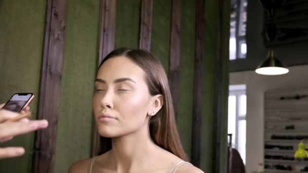 Maquillaje artista haciendo maquillaje para asiático mujer con ojo lápiz en salón de belleza — Vídeos de Stock