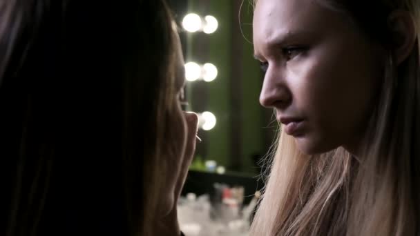 Attraktiv kaukasiska makeup artist gör makeup för ung kvinna i skönhetssalong — Stockvideo