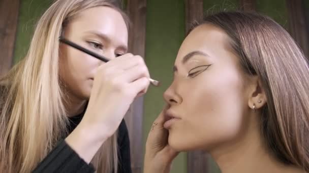 迷人的高加索化妆师在美容院为亚洲女性化妆 — 图库视频影像