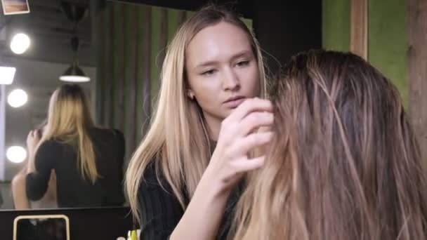 Maquiagem artista fazendo cabelo styling para mulher asiática com óleo no salão de beleza — Vídeo de Stock