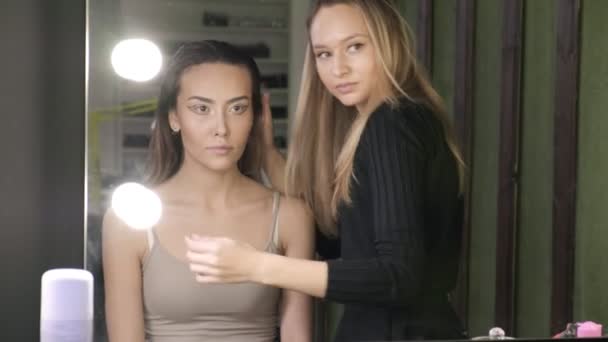 Make-up umělec tvorby účesů pro asijské ženy s olejem v salonu krásy — Stock video