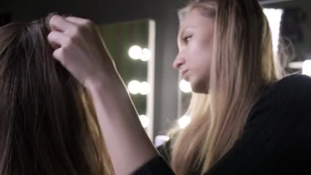 Artista de maquillaje haciendo peinado para mujer asiática con aceite en salón de belleza — Vídeo de stock