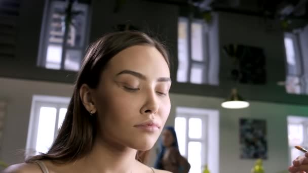 Joven morena bonita mujer con maquillaje creativo mirando el espejo en el salón — Vídeos de Stock