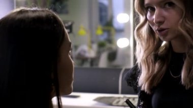 Makyaj sanatçısı güzellik salonunda genç Asyalı çekici bir kadın için makyaj yapıyor.