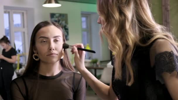 Makeup artist gör makeup för attraktiva unga asiatiska kvinna i skönhetssalong — Stockvideo