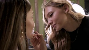 Makyaj sanatçısı güzellik salonunda genç Asyalı çekici bir kadın için makyaj yapıyor.