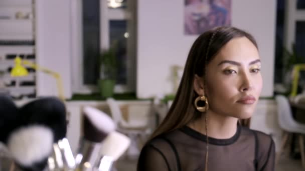 Makeup artist gör kompensera för attraktiva unga asiatiska kvinna i skönhetssalong — Stockvideo