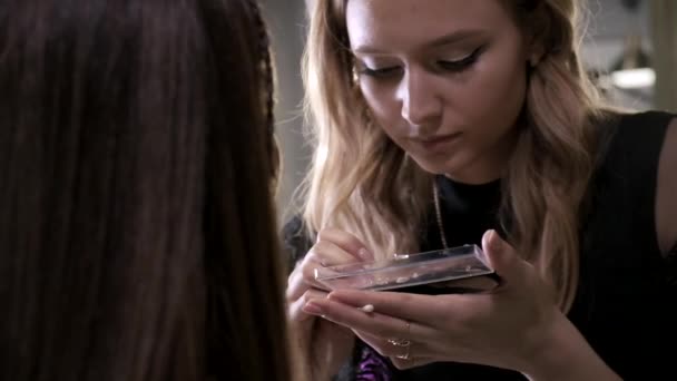 Makeup artist gör kompensera för attraktiv ung brunett flicka i skönhetssalong — Stockvideo