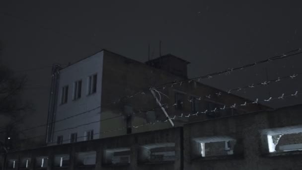 Vězení ostnatý drát přes betonový plot za studena tmavá zimní noc během sněžení — Stock video