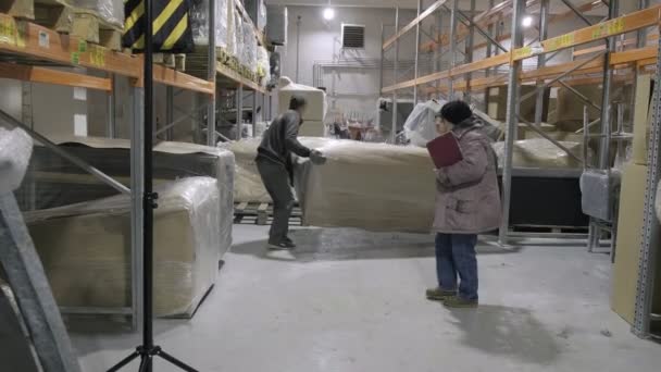 RUSSIA, VLADIMIR, 30 MAR 2021: two movers work at furniture production storage — Stock Video