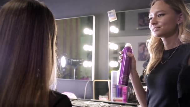 Coiffeur pulvérisation coiffure sur coiffure de fille à l'institut de beauté ou salon de coiffure — Video