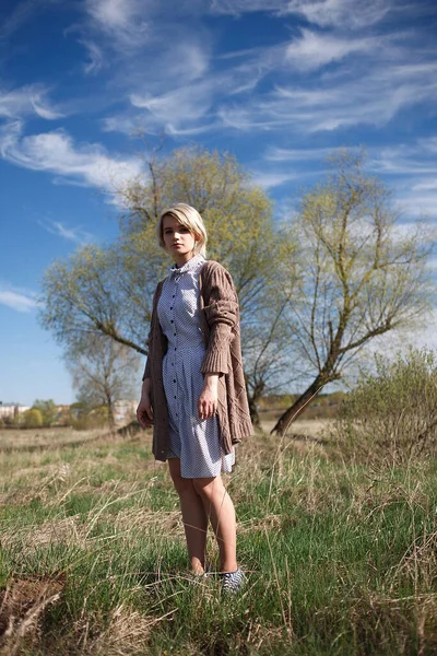 Young attractive caucasian female stands at field on sunny day in front of tree — Stock Photo, Image