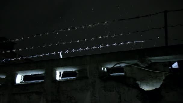 Prisión alambre de púas sobre valla de hormigón en la fría noche de invierno oscura durante la nevada — Vídeos de Stock