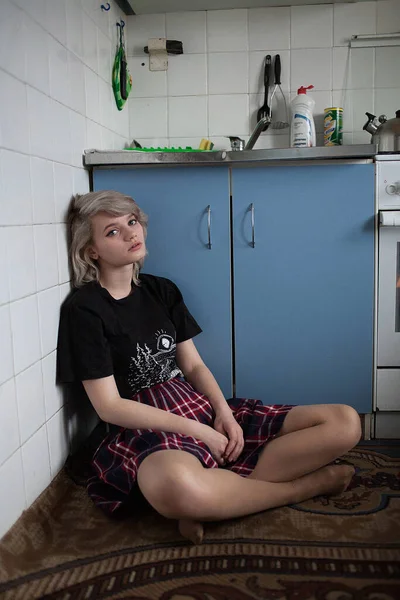 Молодая привлекательная кавказка, сидящая на полу на старинной кухне — стоковое фото