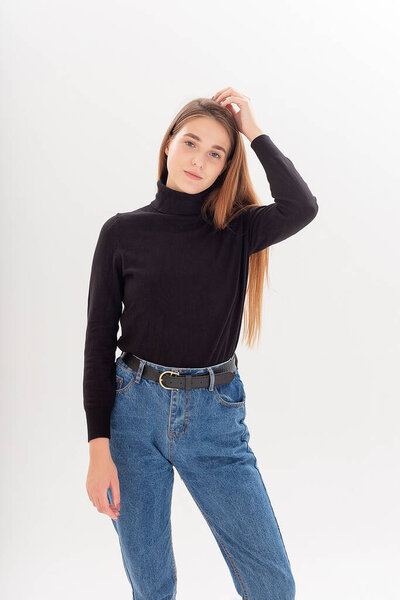 young attractive caucasian woman with long hair in black turtleneck, blue jeans