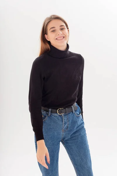 Young attractive caucasian woman with long hair in black turtleneck, blue jeans — Stock Photo, Image