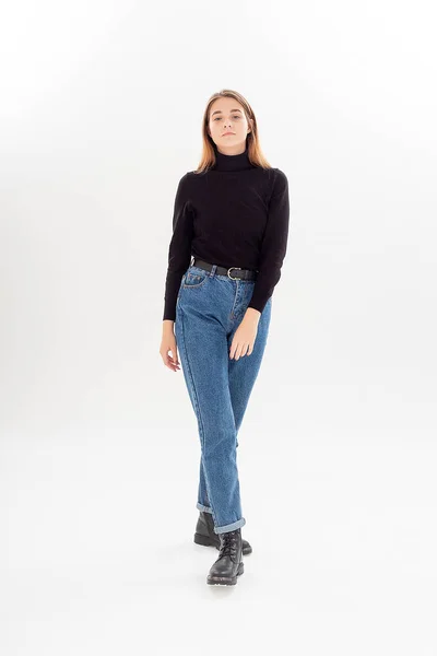 Jonge aantrekkelijke Kaukasische vrouw met lang haar in zwart coltrui, blauwe jeans — Stockfoto