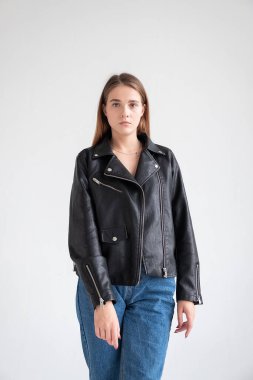 Siyah ceketli, mavi kotlu, uzun saçlı, beyaz bir kadın.