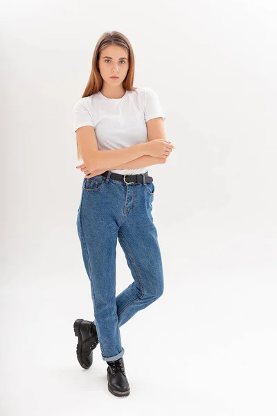 Jong Kaukasisch mooi meisje met lang haar in t-shirt, blauwe jeans in studio — Stockfoto