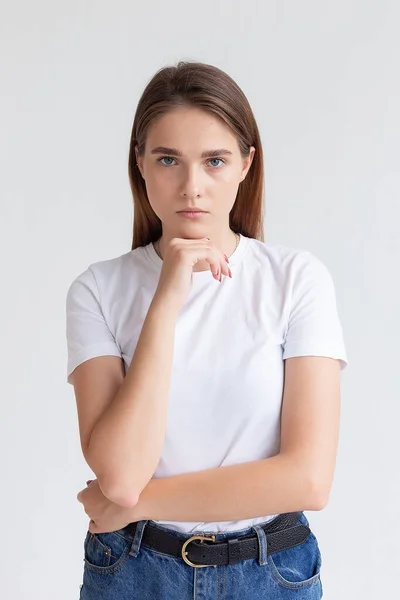 Jovem caucasiano menina bonita com cabelos longos em t-shirt, jeans azuis no estúdio — Fotografia de Stock