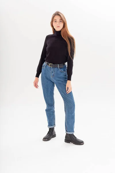 Ung attraktiv kaukasiska kvinna med långt hår i svart polotröja, blå jeans — Stockfoto