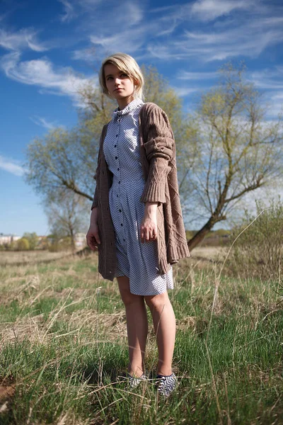 Young attractive caucasian female stands at field on sunny day in front of tree — Stock Photo, Image