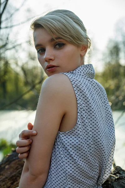 Bahar güneşli bir günde bataklıkta kısa saçlı beyaz bir kadın.