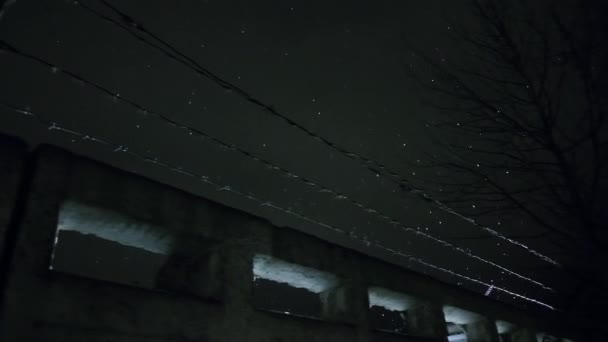 Prison barbed wire over concrete fence at cold dark winter night during snowfall — Stock Video