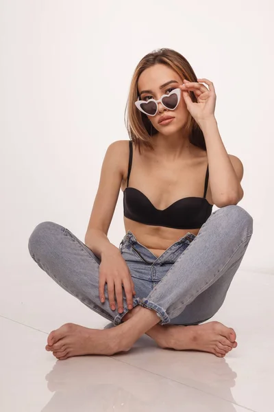 Sexy asiático menina posando em lingerie, jeans, óculos de sol no branco estúdio fundo — Fotografia de Stock