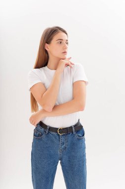 Uzun saçlı, uzun saçlı, stüdyoda kot pantolon giyen beyaz bir kız.