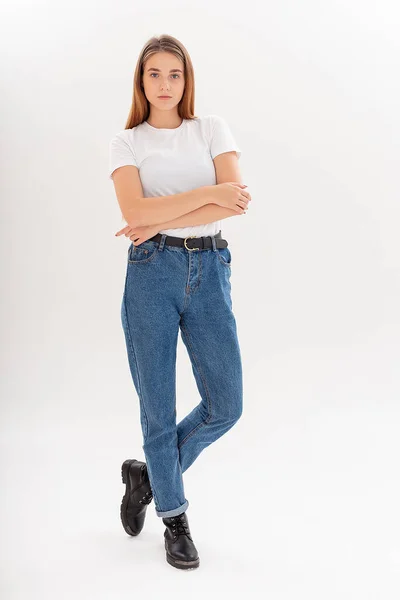 Joven caucásico bonita chica con el pelo largo en camiseta, pantalones vaqueros azules en el estudio —  Fotos de Stock