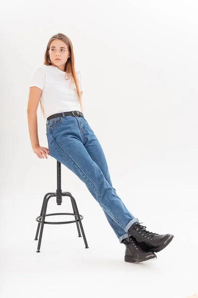 Joven caucásico bonita chica con el pelo largo en camiseta, pantalones vaqueros azules en el estudio — Foto de Stock